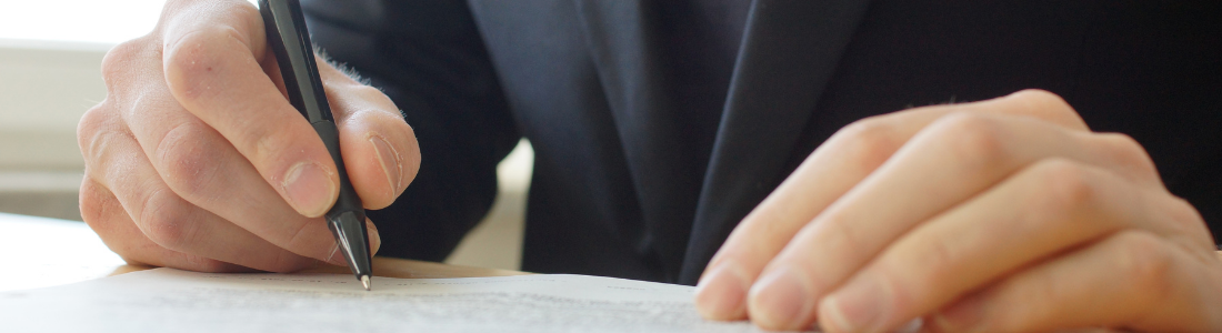 Close up of person signing a document